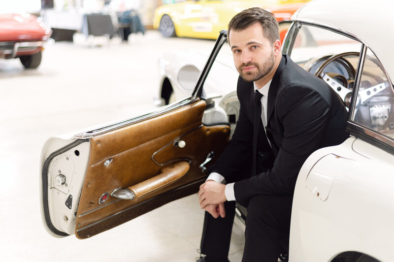 man in suit in a 1960 Corvette convertible