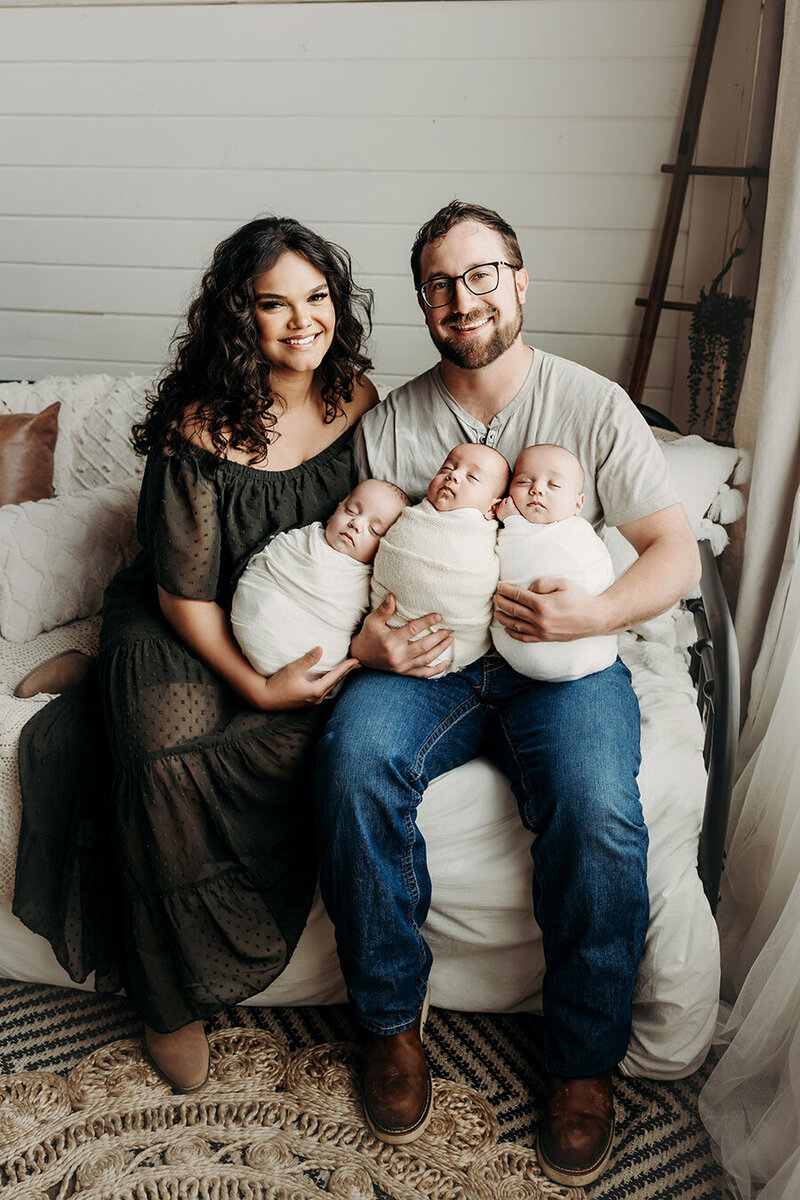 Mom and dad with their newborn triplets