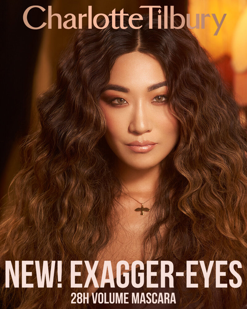 Charlotte Tilbury Exagger-Eyes 28H Volume Mascara campaign featuring Soo Youn Lee, showcasing voluminous curls and bold makeup in a luxurious setting.