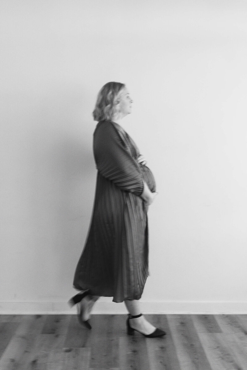 blurred photo of pregnant mom walking across studio