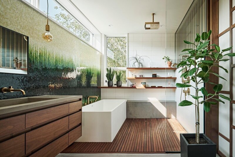 Cast concrete bench in residential wet room with wood floor, porcelain bathtub and rain head shower