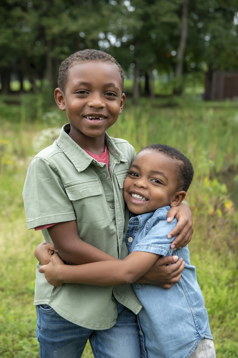Two siblings hugging and smiling together 