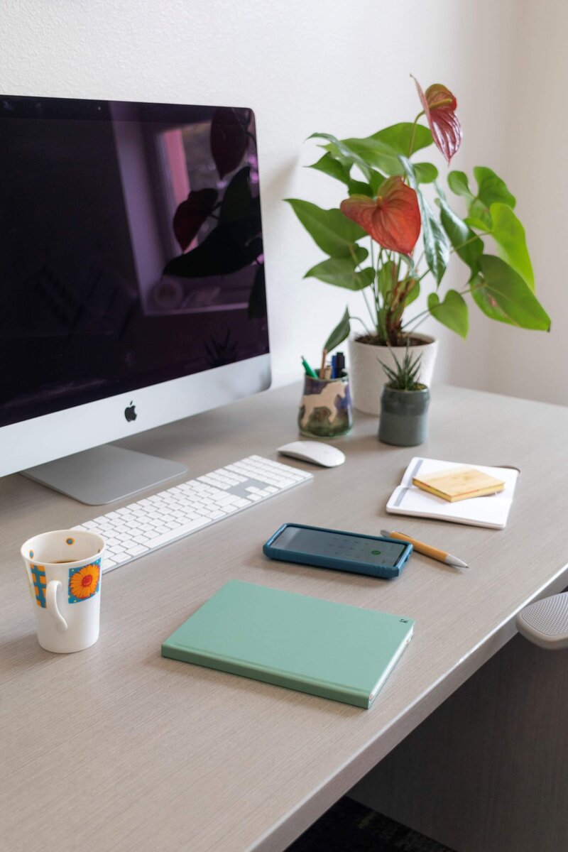 desk with computer, coffee, notebook, pencil and pad of paper