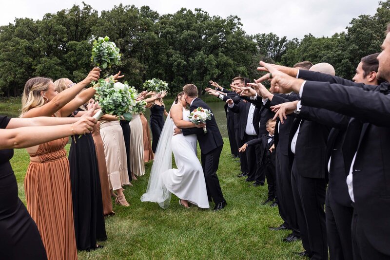 bride-groom-kissing-wedding-party