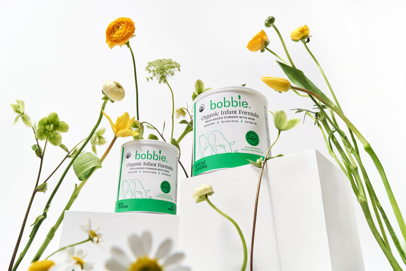 Containers of baby formula surrounded by flowers