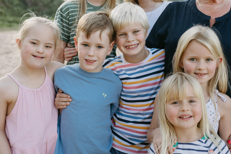 Cousins hugging with their grandmother, they are joyful and in the moment