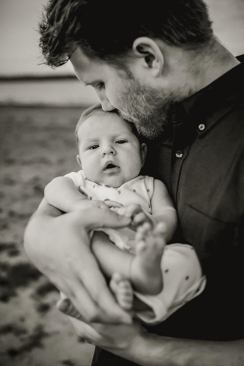 father kisses the top of his son's head a photo session in southlake texas