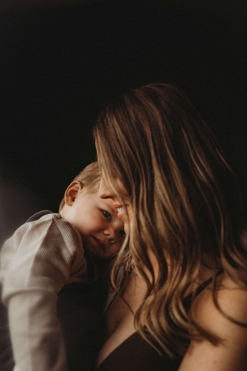 Tiny toddler fingers curled around a flower stem during a lifestyle family session