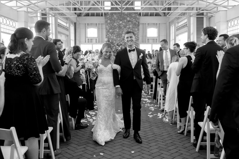 Couple in wedding attire holding hands and walking up the steps at NYC city hall
