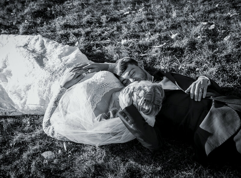 Bride and Groom laying on ground, Black & White photo