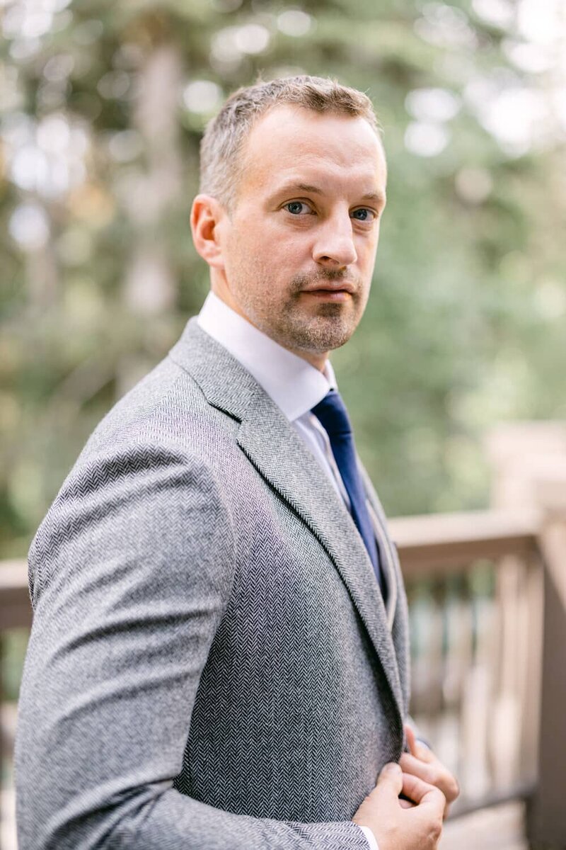 This refined portrait captures the groom as he prepares for his wedding day at Emerald Lake Lodge in Yoho National Park. The serene lodge setting and natural light highlight the groom’s anticipation and elegance, creating a timeless moment before the ceremony.