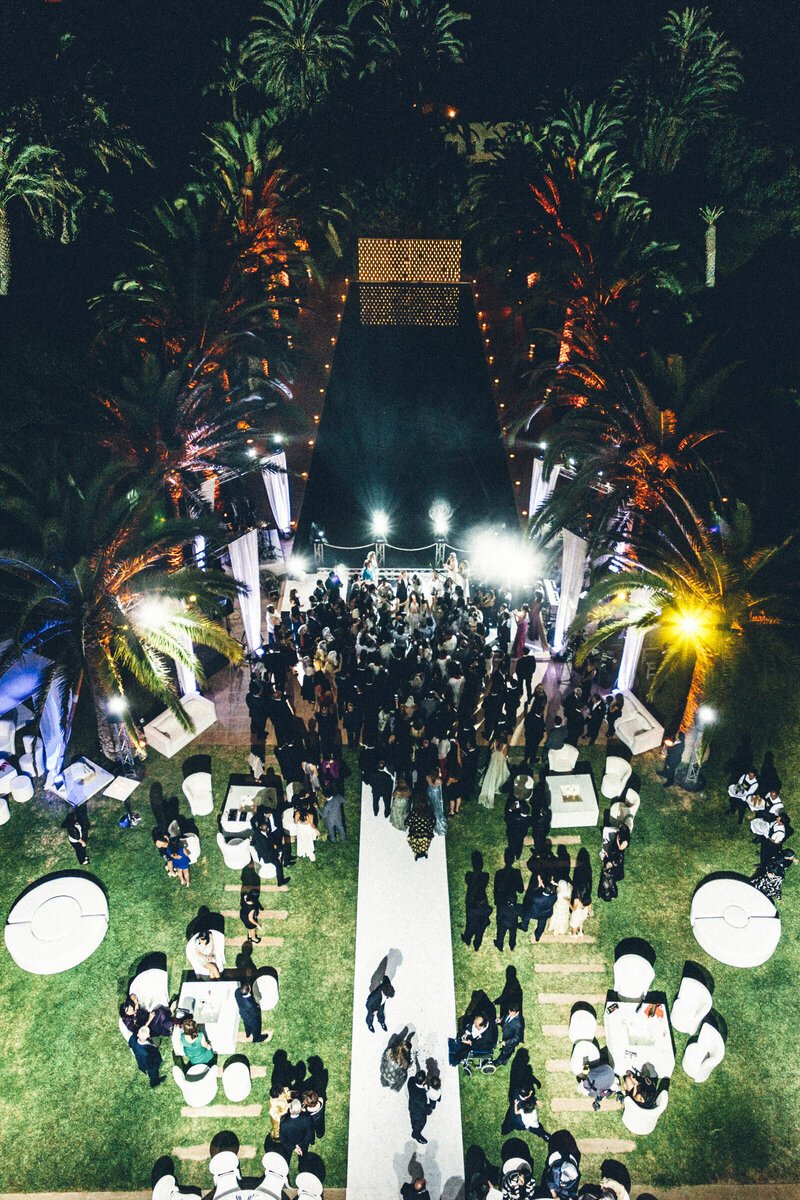 Aerial night view of wedding guests enjoying luxury outdoor celebration.