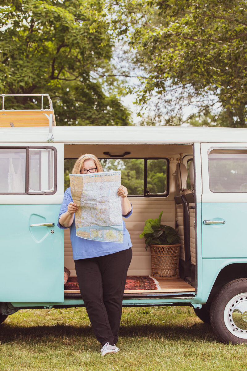 brand image of female reading a map with VW bus