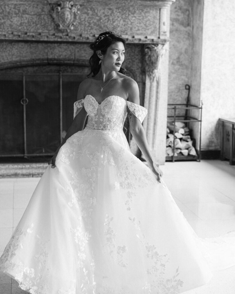 This stunning portrait captures the bride inside the Banff Springs Hotel, with a grand fireplace behind her as she gazes out the large windows toward the mountains. The luxurious setting and breathtaking views create an elegant and timeless moment on her special day.