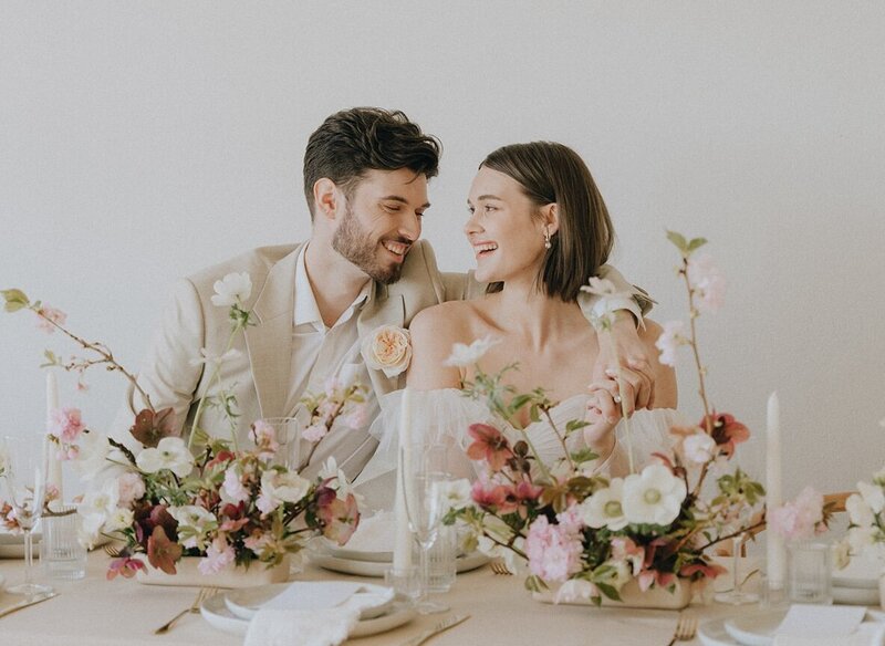 couple smiling at each other at the reception table