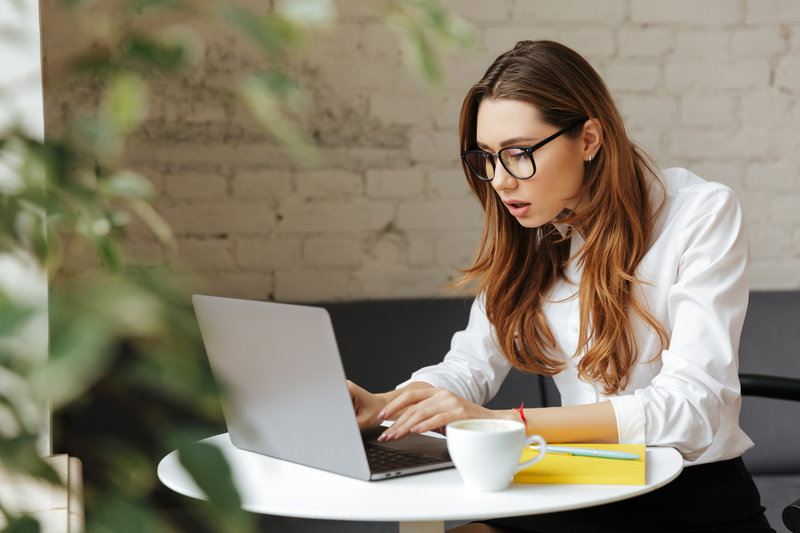 confused-business-lady-indoors-using-laptop-PTYNASW