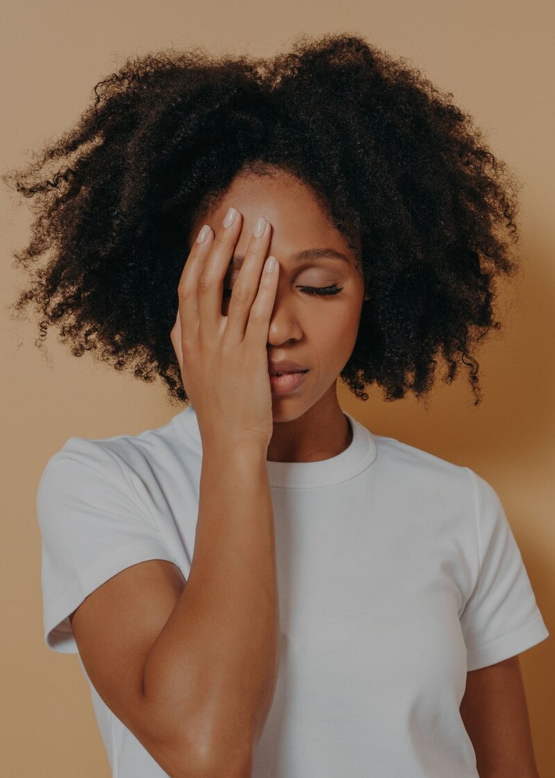 A woman covering one eye with her hand. Relationship Experts in Florida and Miami, FL offer EMDR therapy to help individuals heal from betrayal trauma and PTSD.