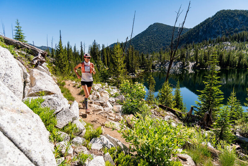 woman in a race on top of a mountain by a lake