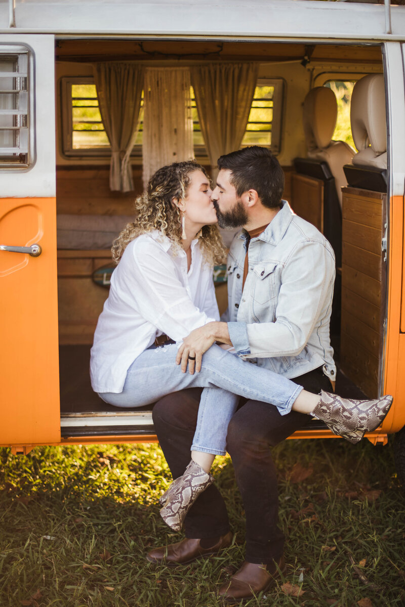 couple sitting in old van kissing during engagement session