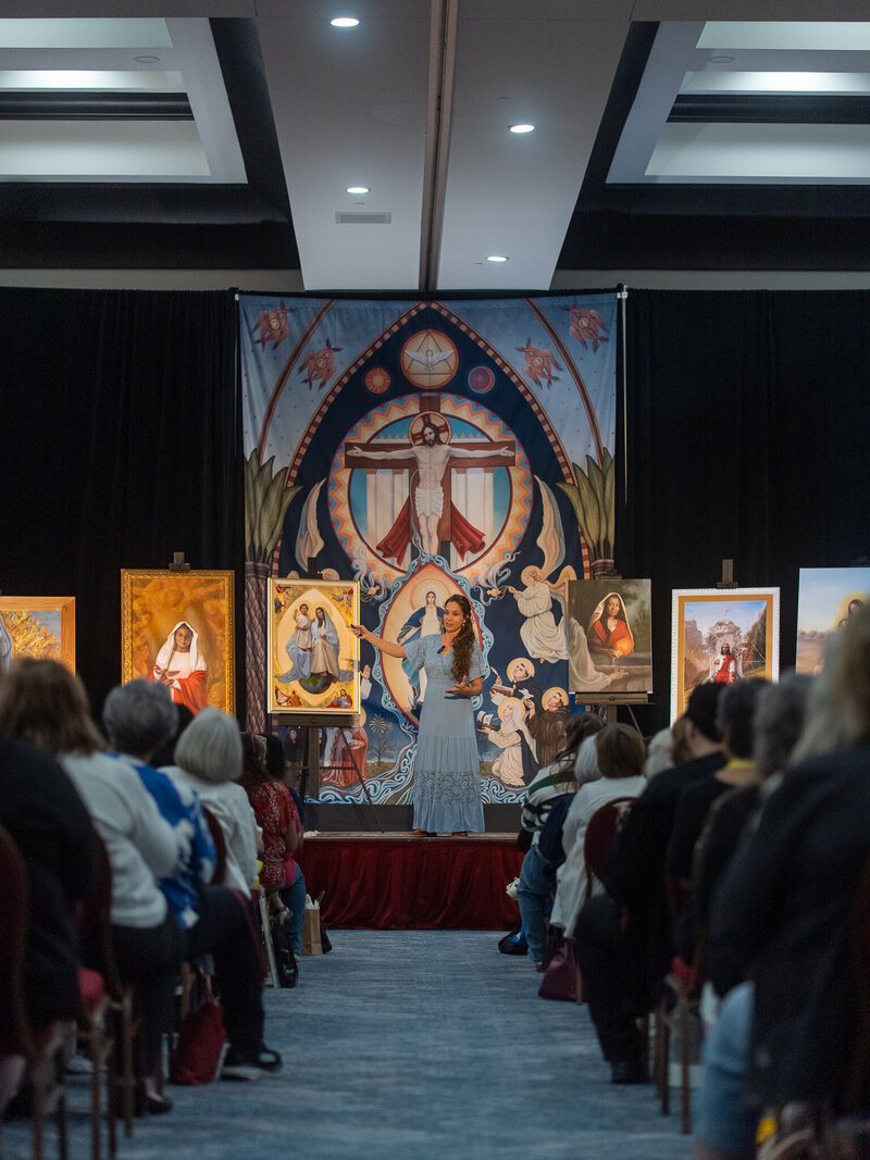 woman speaking over artwork