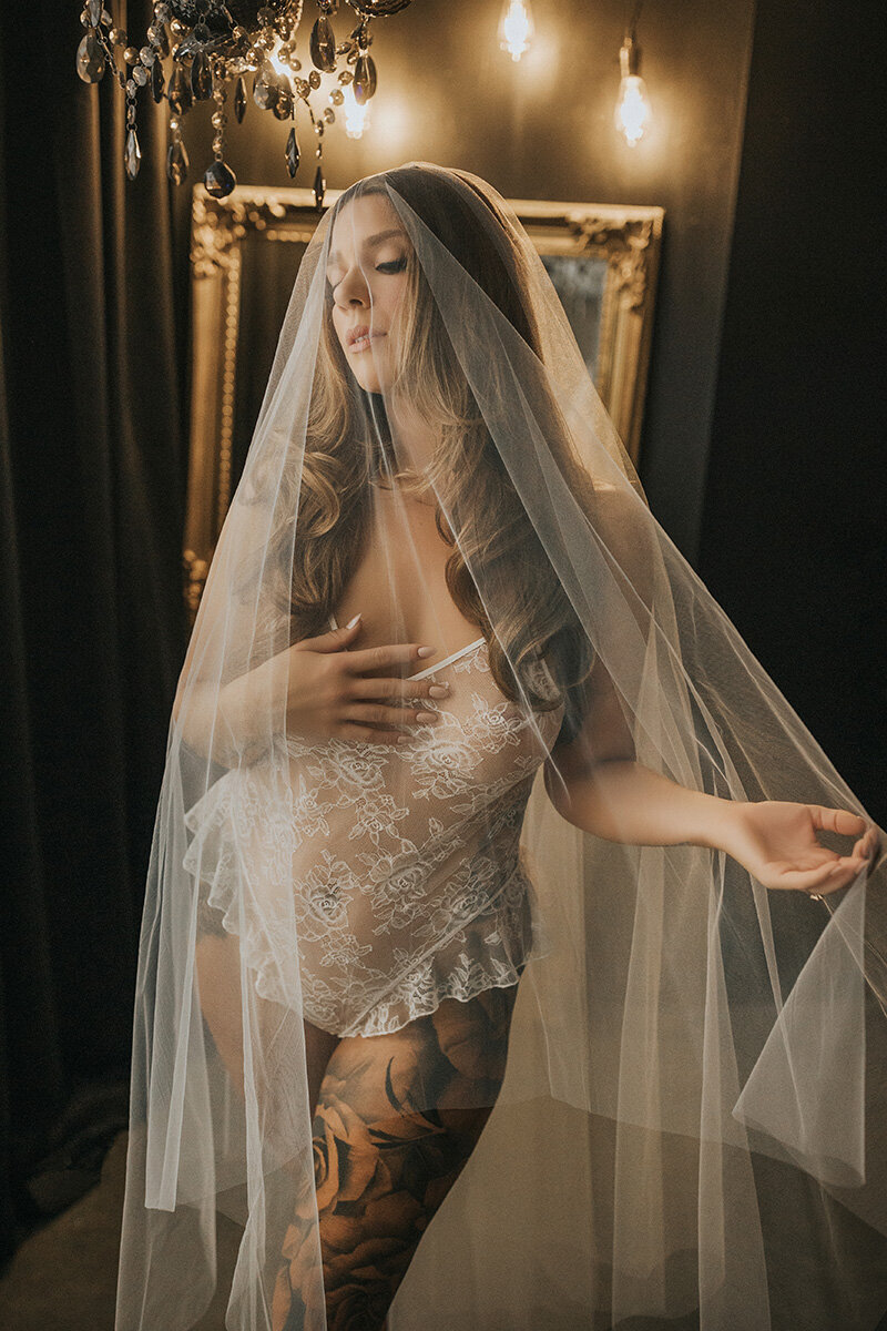 future bride poses with her veil during boudoir photoshoot in vancouver bc studio