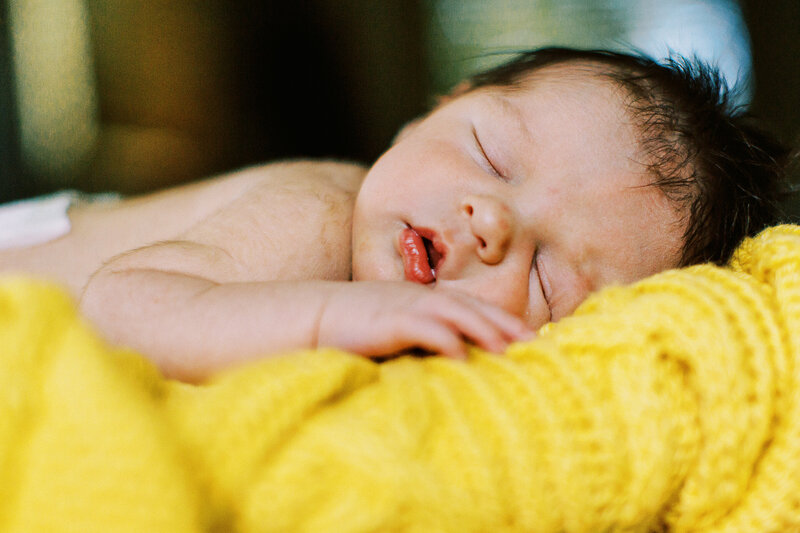 sleeping newborn baby boy on a yellow blanket in loveland, colorado