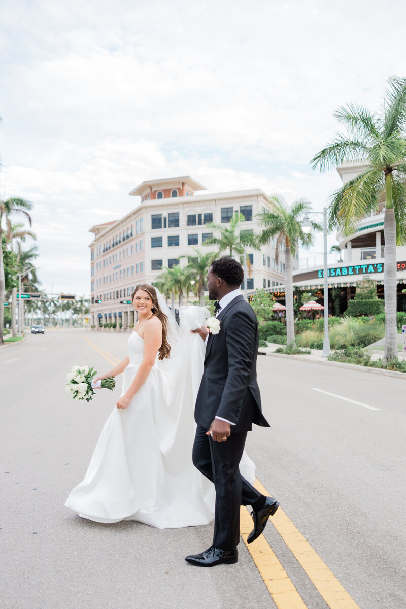 A couple crossing the street at their wedding at the Ben, Autograph Collection in West Palm Beach. 
