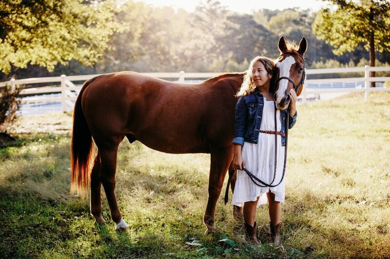 Senior portrait of a girl with her horse in a field