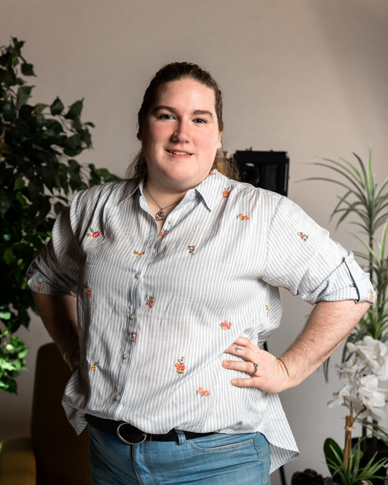 Delaney Lux, Northeast Ohio wedding and elopement photographer, standing confidently in her home studio