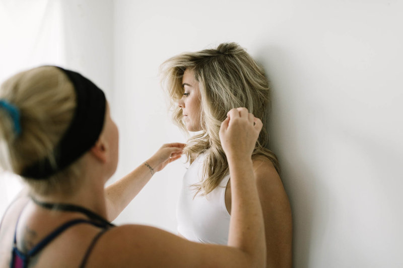 Hair stylist touches up during boudoir session with Boudoir by Elle