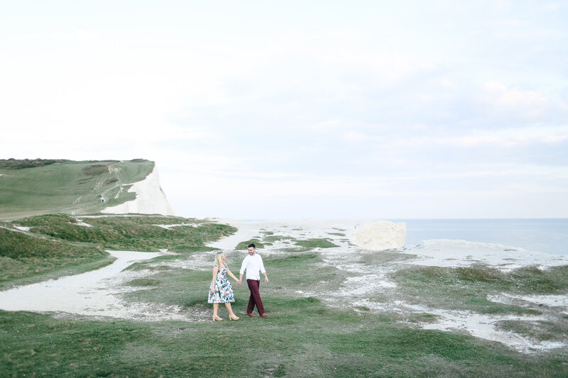 couple-walking-above-cliffs-during-engagement-shoot-in-berkshire-by-leslie-choucard-photography