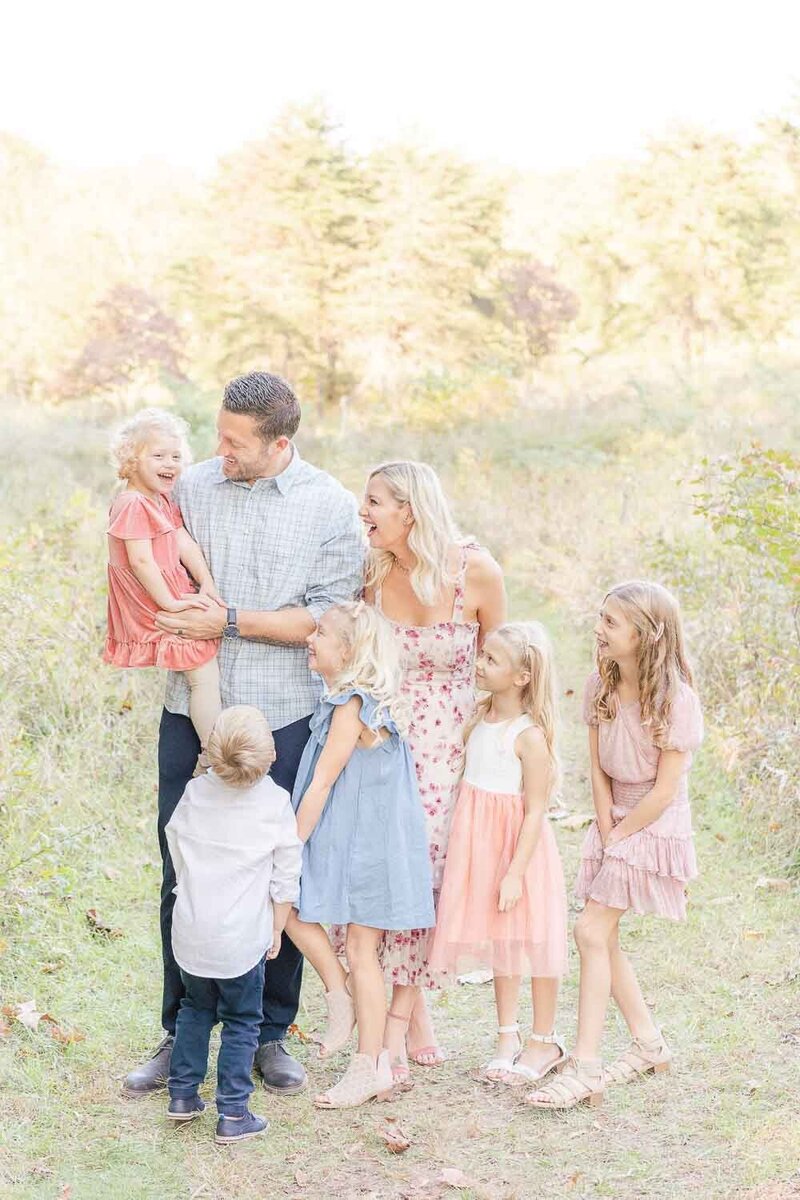 family of 7 looking at the youngest and laughing during Prince William County, Virginia fall mini session