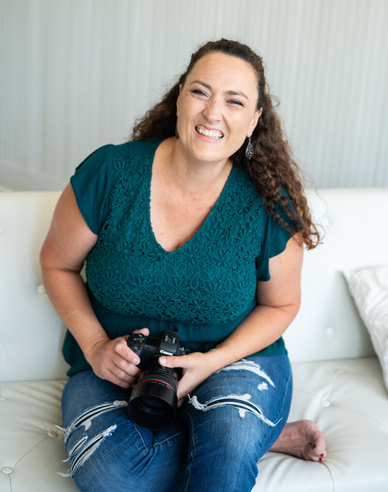 photographer holding camera infront of white wall