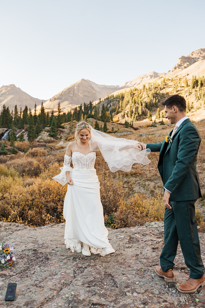A tiny couple kiss at sunset at a mountain lake in Breckenridge
