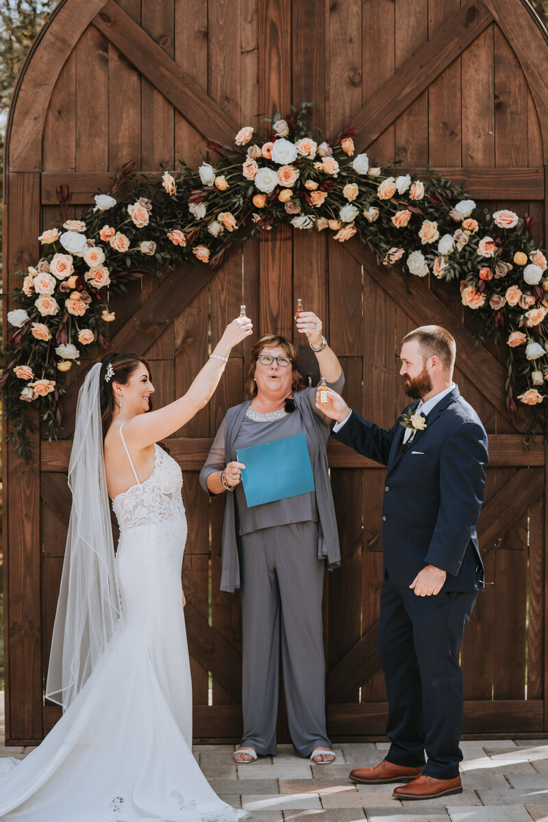 bride and groom standing with wedding officiant