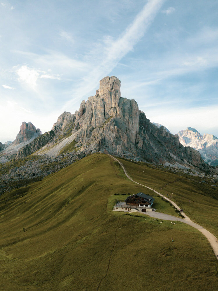 Giau Pass | The large mountain Ra Gusela looms over a rolling green alpine meadow