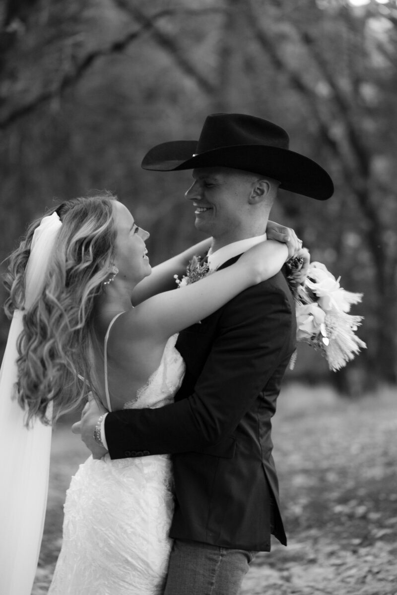 Wedding couple walking hand in hand outdoors, groom wearing a traditional lei during their mountain wedding