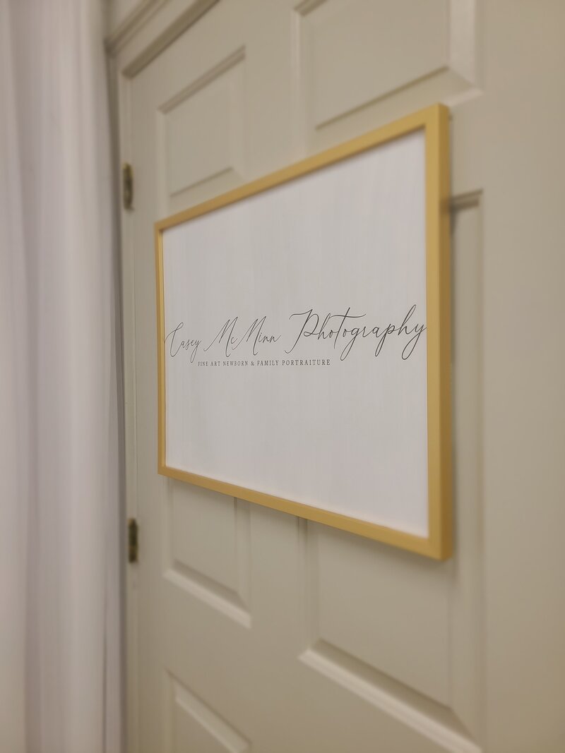Casey McMinn Photography studio sign on door in gold frame