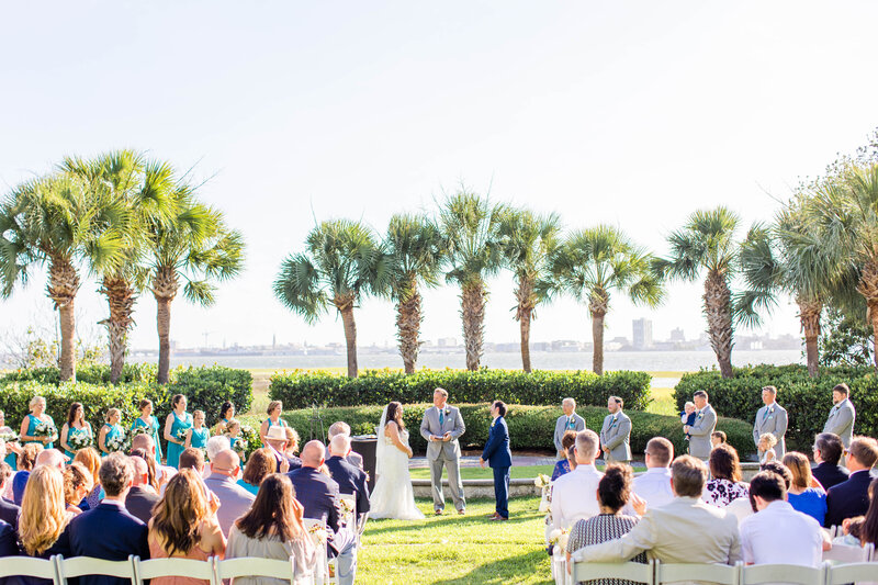 bride and groom at ceremony on their wedding day with palm trees and water behind them