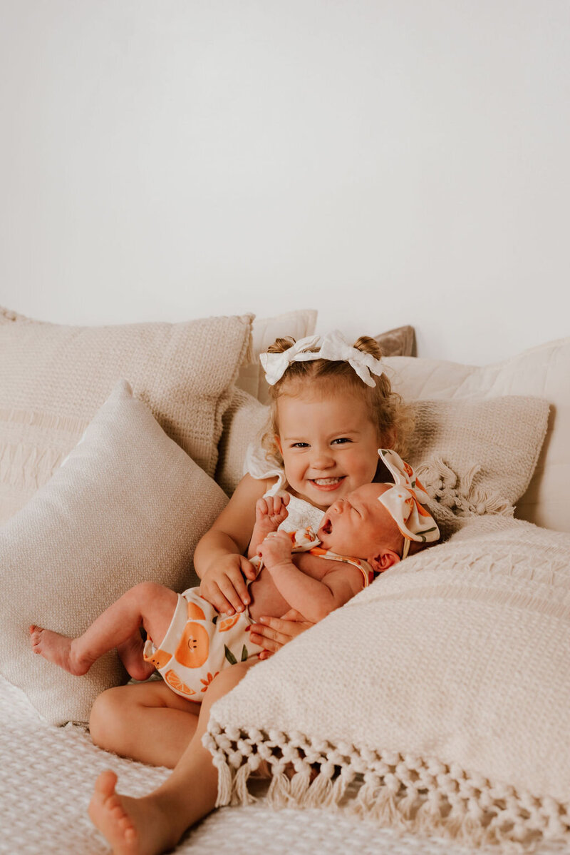 little girl holds baby sister during family photos in peoria il