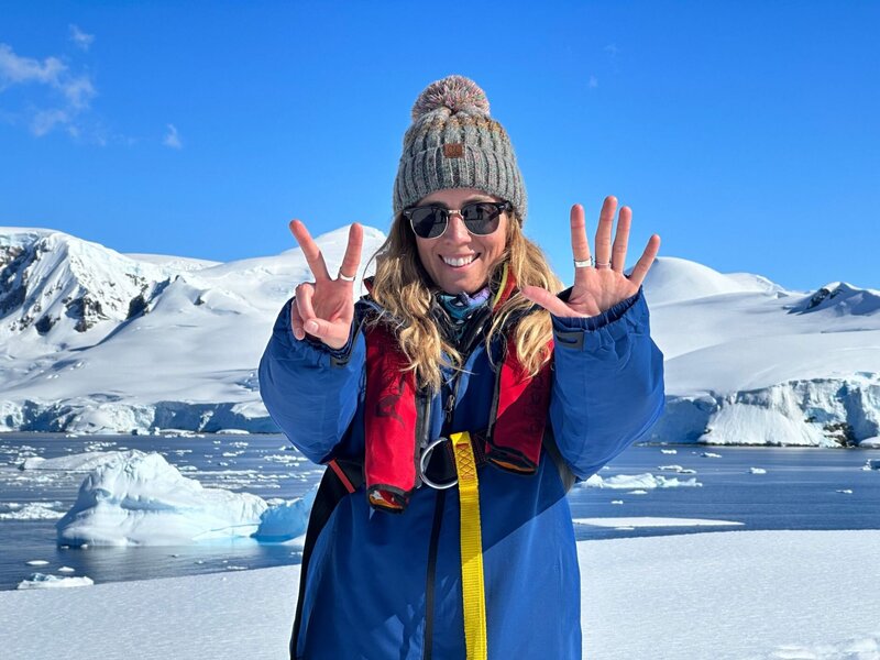 Micaela holding up seven fingers for her last continent in Antarctica