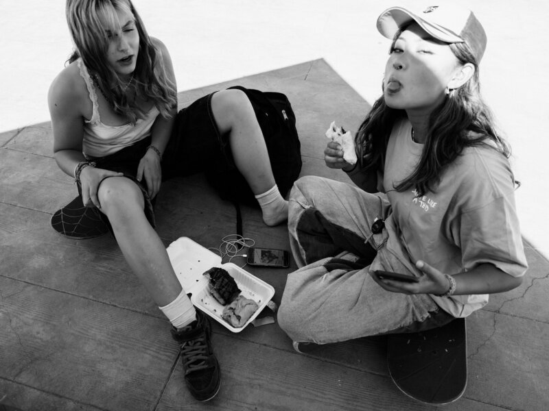 Two skater girls eating food
