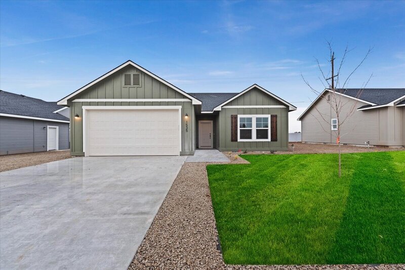 sage green house with brown door and white garage door