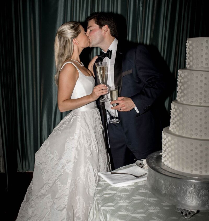 Picture of bride and groom toasting and kissing on their wedding day