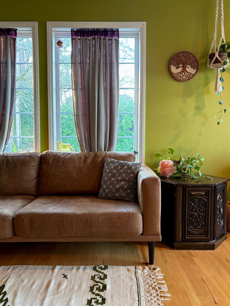 A couch and sidetable in Emily's office where she provides holistic and integrative therapy services.