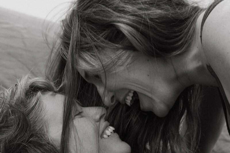 Black and white close-up of a couple laughing together. The image captures their joyful expressions and close bond, emphasizing their love and connection.
