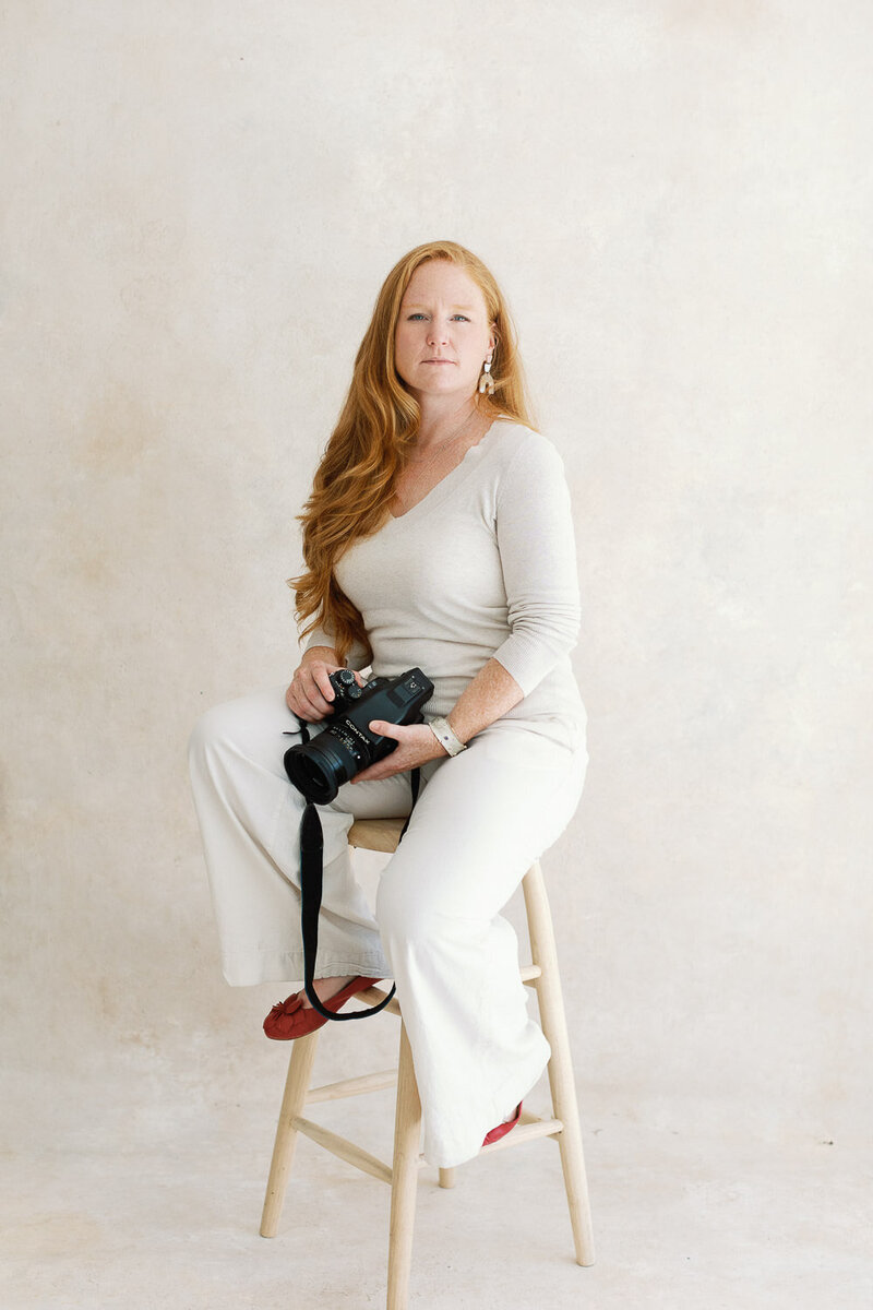 Photographer, Coryn Kiefer, poses for photo holding camera