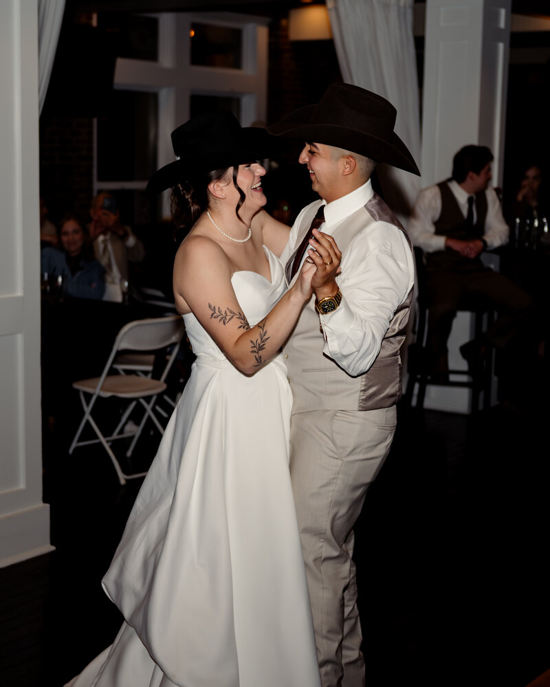 A louisville catholic couple dances at their bourbon-loft reception in downtown louisville while wearing cowboy hats after their wedding mass at St. Boniface Catholic Church