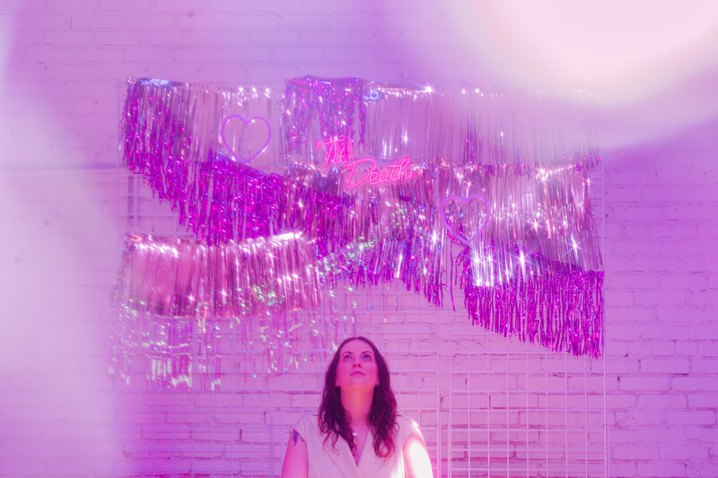 Woman under a tinsel wedding display wall