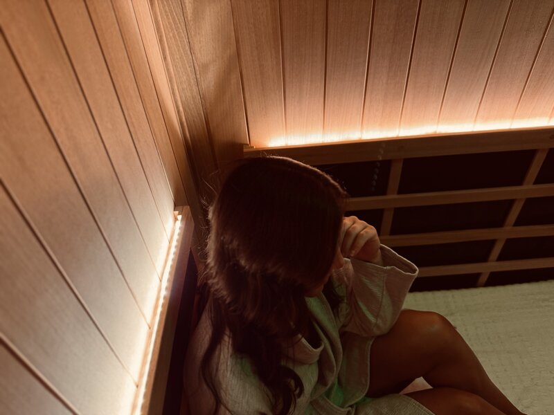 Man in a towel sitting in an Infrared sauna suite